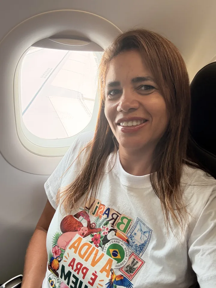 Cirlene sentada junto à janela do avião